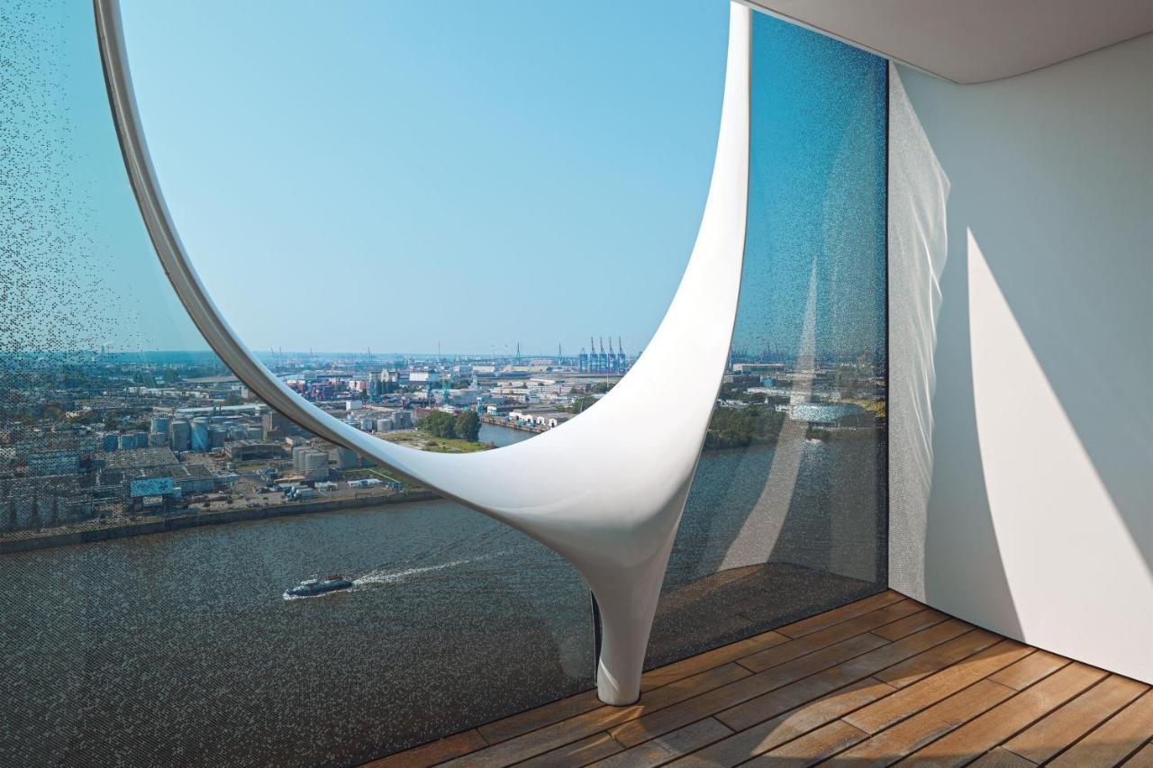 The Westin Hamburg Elbphilharmonie Hotel Екстериор снимка The photo showcases a modern architectural interior featuring a large, uniquely designed window that creates a dramatic visual effect. The window has an organic, flowing shape, resembling a sculptural element, and is made of glass that allows natural