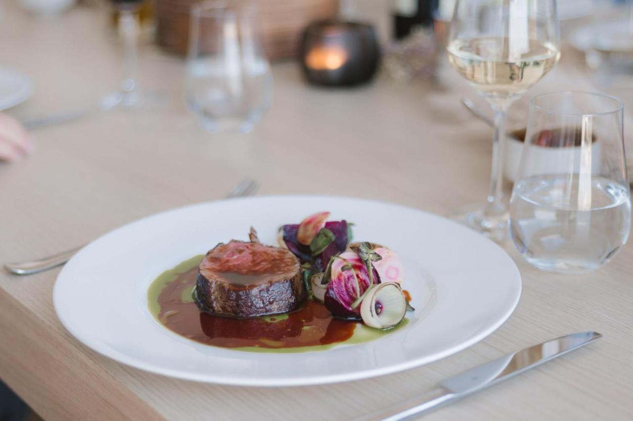 The Westin Hamburg Elbphilharmonie Hotel Екстериор снимка The photo shows a beautifully presented plate of food, featuring a piece of meat, likely a fillet, sliced neatly and arranged at the center. It is accompanied by a rich, glossy sauce that pools around the meat. Surrounding the meat are colorful edibl