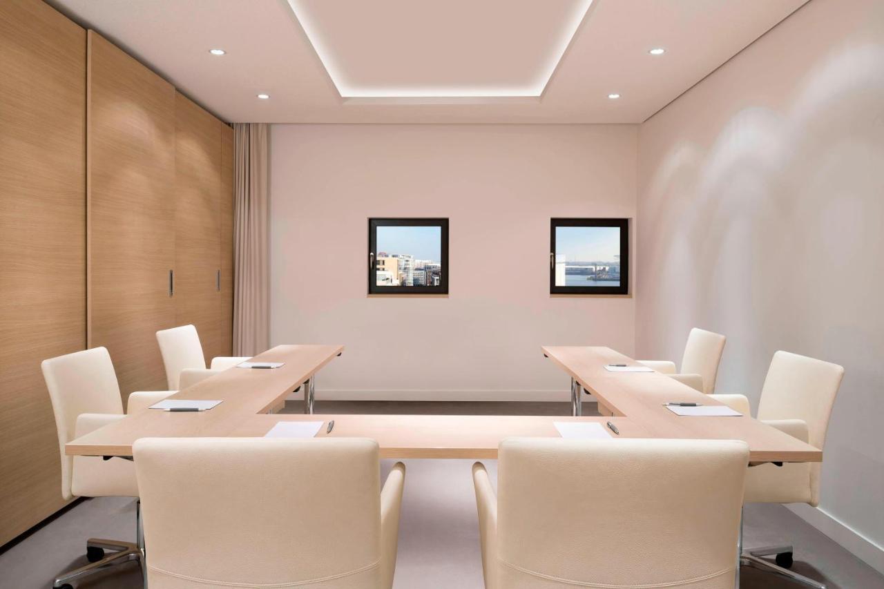 The Westin Hamburg Elbphilharmonie Hotel Екстериор снимка The photo shows a modern conference room. It features a long, rectangular table made of light-colored wood, surrounded by several cream-colored chairs. The walls are painted in a light shade, and there are two framed windows on one wall that provide 