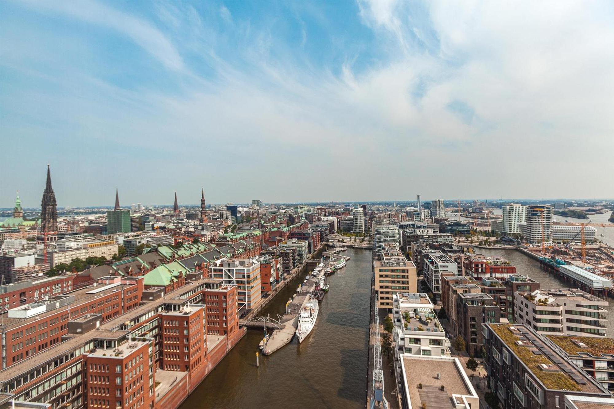 The Westin Hamburg Elbphilharmonie Hotel Екстериор снимка The photo shows an aerial view of a cityscape with a prominent waterfront area. There are modern and historic buildings lining both sides of a river or canal, suggesting an urban environment. The architecture appears diverse, with a mix of contempora
